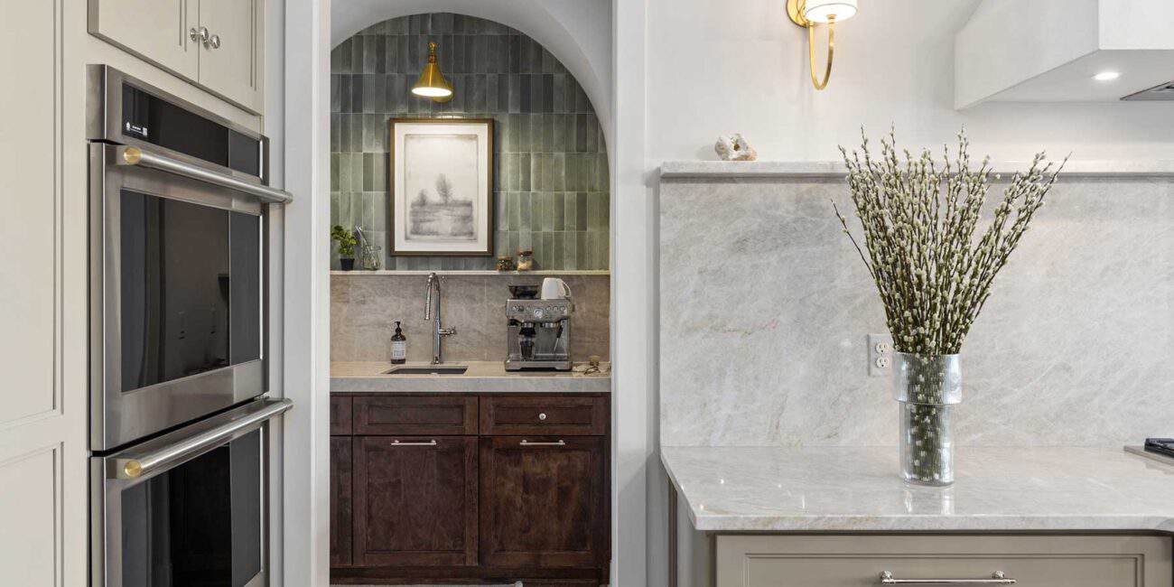 The back pantry makes a beautiful impression, staged in an arched opening with brick tile in sage. It makes the perfect coffee station next to a small sink for easy cleanup.