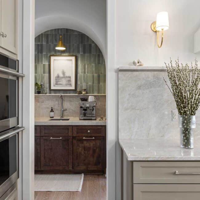 The back pantry makes a beautiful impression, staged in an arched opening with brick tile in sage. It makes the perfect coffee station next to a small sink for easy cleanup.