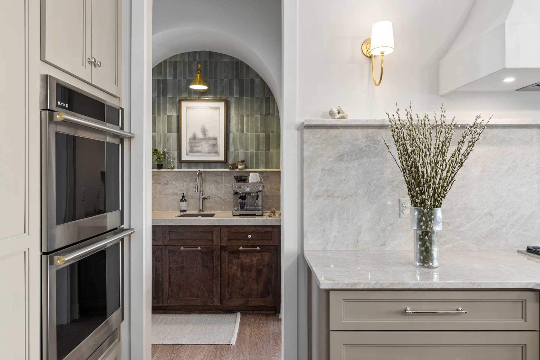 The back pantry makes a beautiful impression, staged in an arched opening with brick tile in sage. It makes the perfect coffee station next to a small sink for easy cleanup.