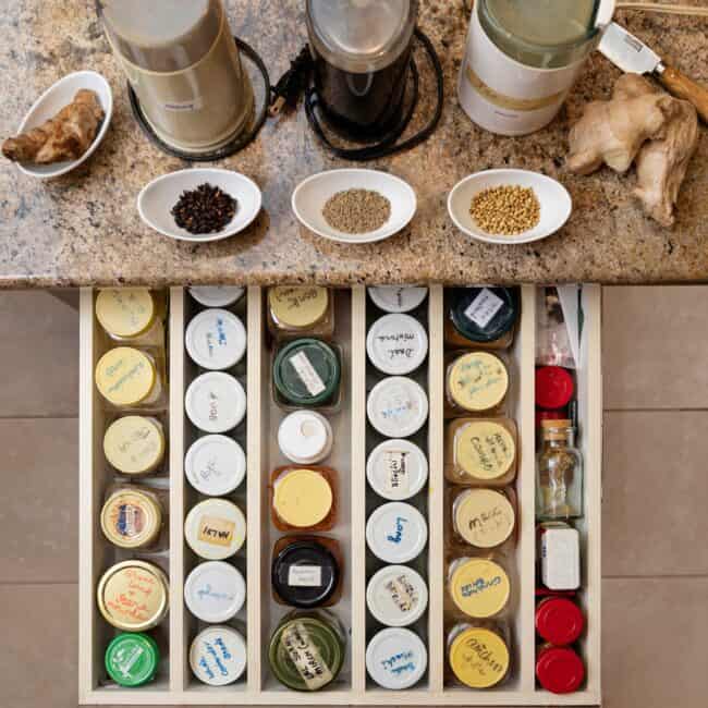 Fresh, homemade herbs and spices are hand-labeled and organized directly across from the stove. Mukharji uses different grinders for the task.