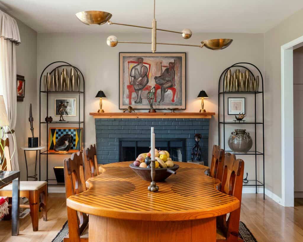 In the dining room, a 1950s abstract by St. Louis artist Kenneth Trueblood sits above the mantle. The unique dining table with its custom inlaid top is from the ’70s. The French art deco étagères hold Ford’s large collection of bronze deco Dirigold bud vases.