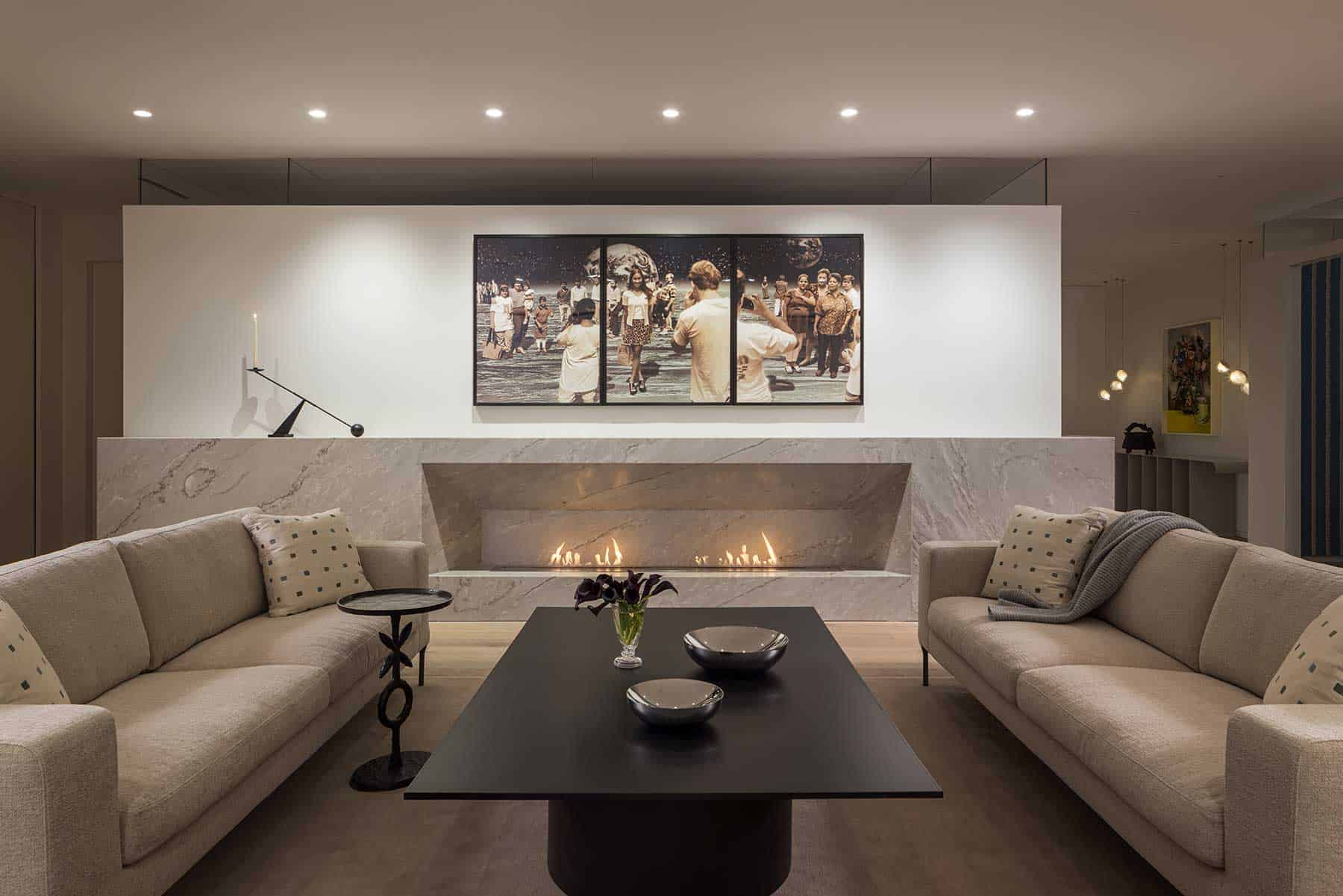 Striking yet calming in its innovative design, the living room features a custom 19-foot BioFlame soft stone fireplace that leaves a blank backdrop for Yoshio Itagaki’s Tourists on the Moon #2, 1998, above. Graphic black furnishings that balance the mood are an ebony-stained white oak drum coffee table designed by Iman and fabricated by Peter Kohl; an Interconnect Candle Holder, designed by Colin King for Audo Copenhagen on the mantle; and a Corbin Bronze XO Table.