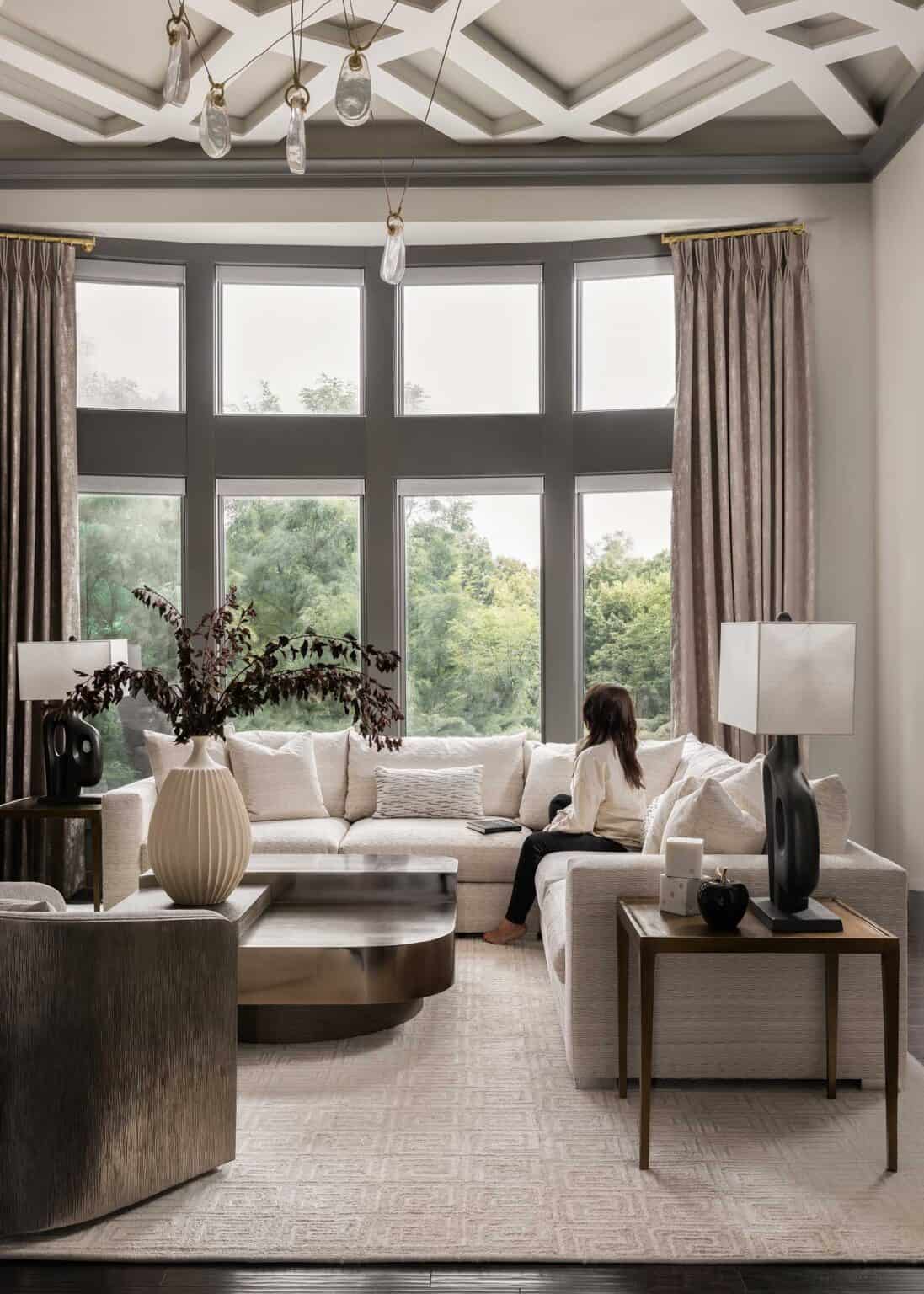 A dramatic multi-light pendant draws the eye up to an equally powerful ceiling detail, while the owners and guests settle in to a grounded, luxe environment.