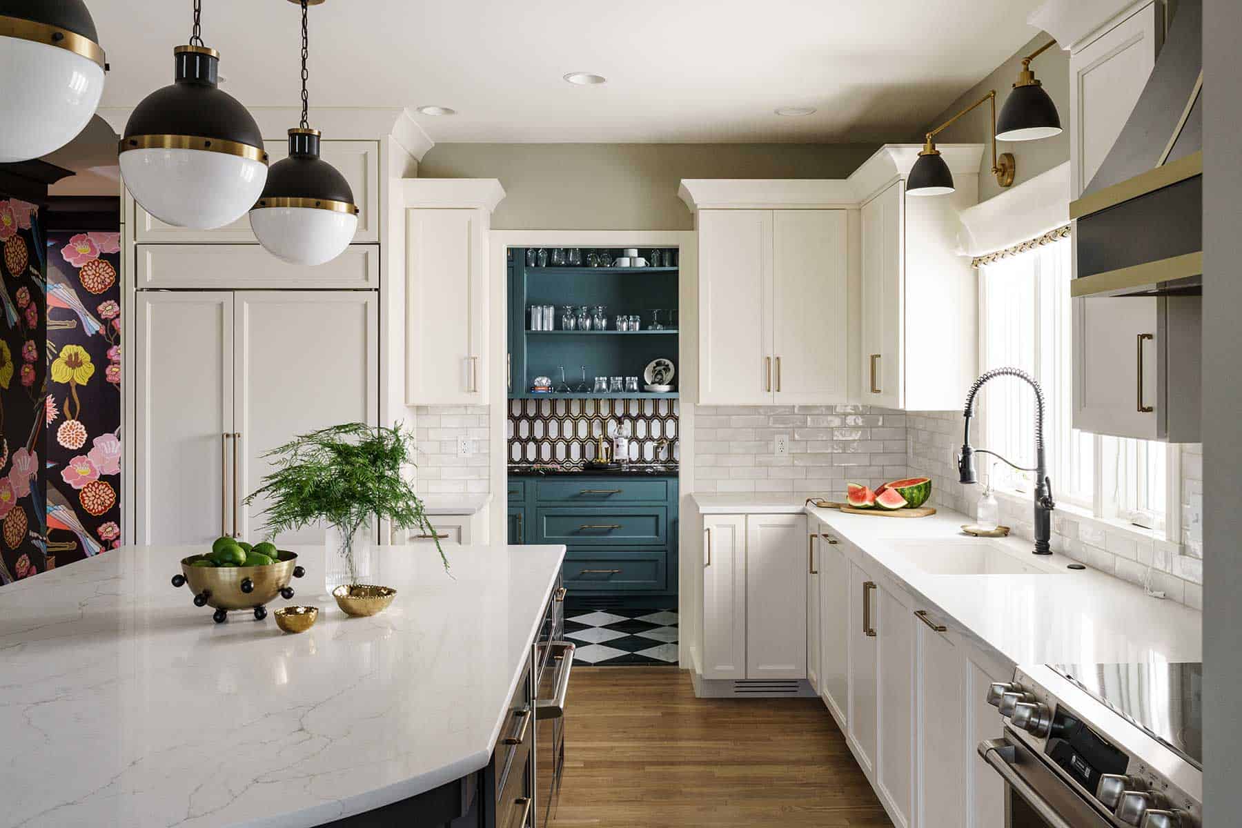 Crisp white cabinets are desirable and timeless, the owners of this kitchen now know. But that didn’t mean they weren’t going to have fun with the details, such as a “speakeasy” style scullery and large-scale mural in the back hall.